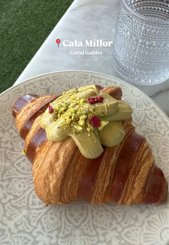 CalaMillor Gourmet Experience in Miami showing review, pistachio croissant, iced latte with leche condensada, cachopo, video by in.theknown on TikTok