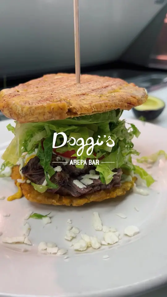 Doggis Arepa Bar in Miami showing food, crispy tostones, marinated churrasco, tomato, lettuce, avocado, doggi’s sauces, video by doggisarepabar on TikTok