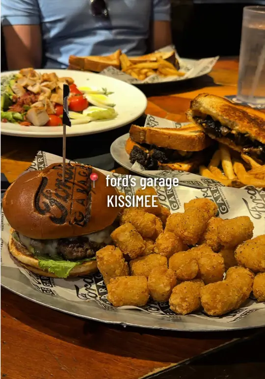 Ford's Garage in Orlando showing restaurant visit, chicken cobb salad, smoked brisket burnt ends melt, cali roadster burger, pulled pork mac and cheese, video by izz.eatsout on TikTok
