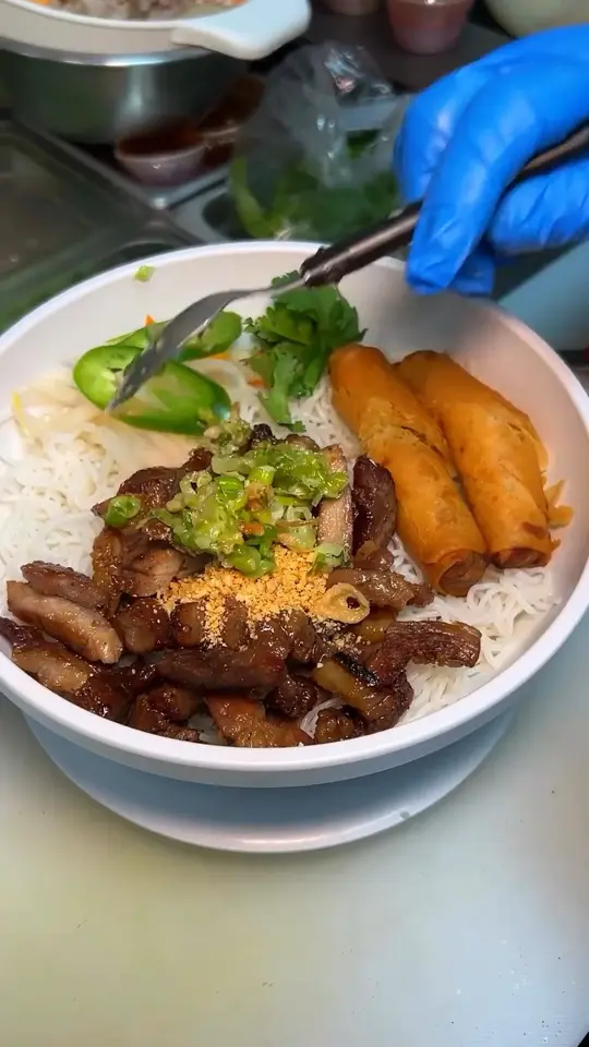 Gạo Restaurant in Tampa showing food, special new menu items, freshly prepped dry noodles, grilled pork, crispy egg rolls, fresh herbs, signature sauce, video by Gạo Restaurant on Facebook