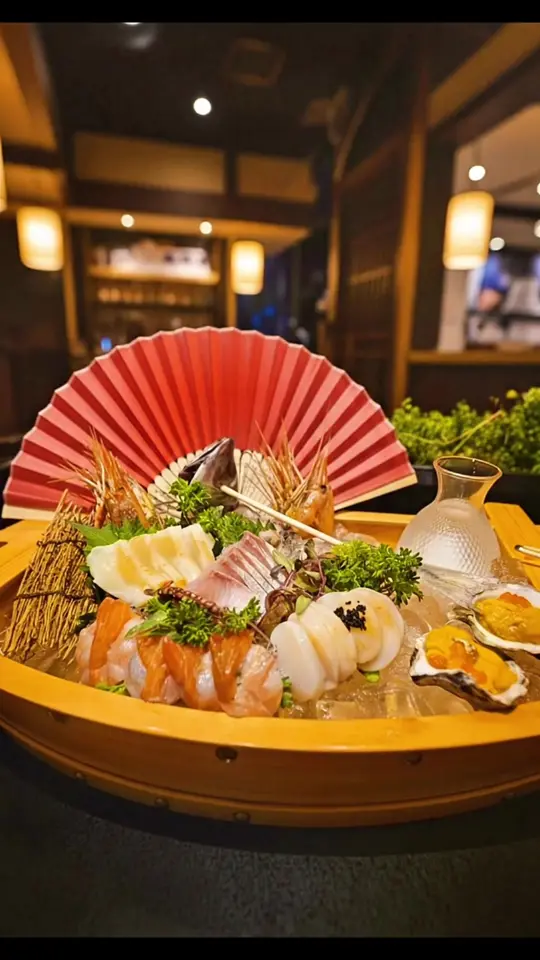 Ichiban Izakaya Restaurant in St. Petersburg showing sashimi boat, sushi, sake, seafood, video by ichibanizakayastpete on TikTok