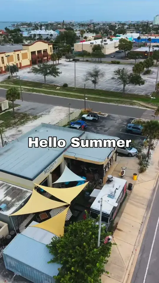 Mastry's Brewing Co in St. Pete Beach showing patio seating, beer, cocktail, summer drinks, video by The Kitchen at Mastry's Brewing Co on Facebook