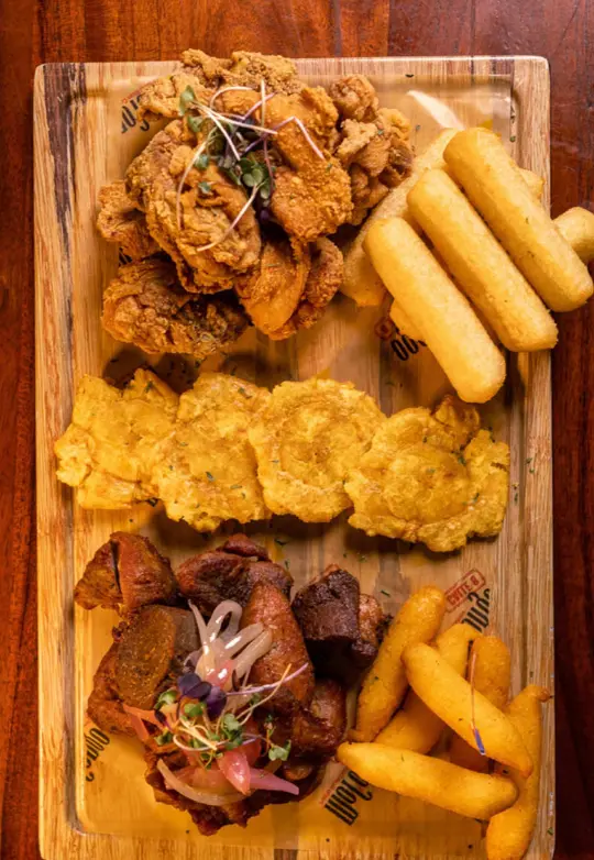 Mofongo Restaurant Calle 8 in Miami showing food, chicken chicharrones, fried pork, corn sorullitos, yucca sticks, tostones, video by mofongorestaurant2 on TikTok