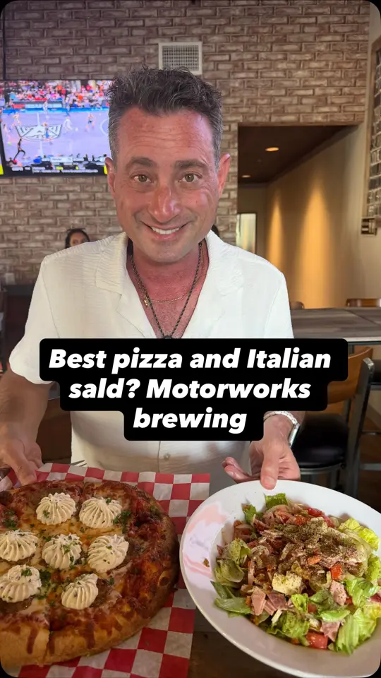 Motorworks Brewing Taproom in Tampa showing pizza, italian salad, video by Foodie Justice on Facebook