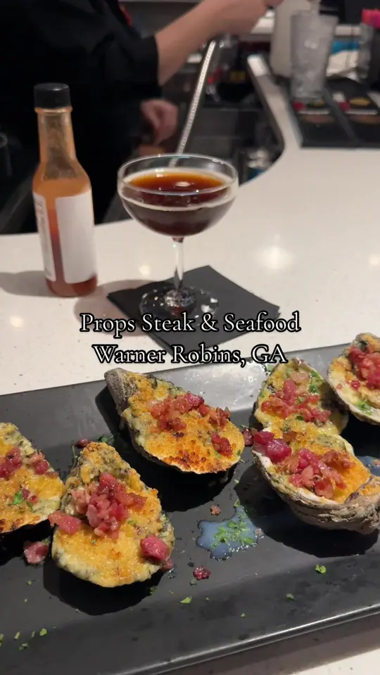 Props Steak and Seafood Restaurant in Warner Robins showing calamari, rockefeller oysters, chicken pasta, shrimp and grits, salmon with scallops, video by dinnerwithericadanielle on TikTok