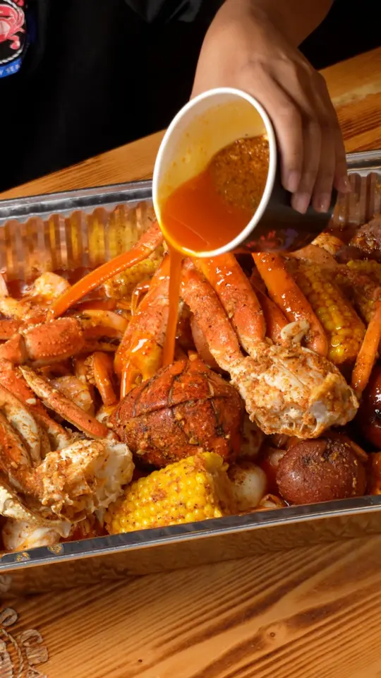 Red Crab - Juicy Seafood & Bar in Port St. Lucie showing seafood boil, sauce drizzle, video by Red Crab - Juicy Seafood on Facebook