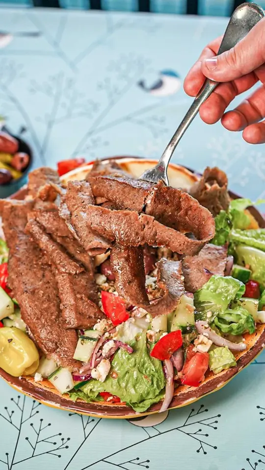 Souvlaki Street in Sunrise showing food, greek salad with gyro meat, video by Souvlaki Street on Facebook