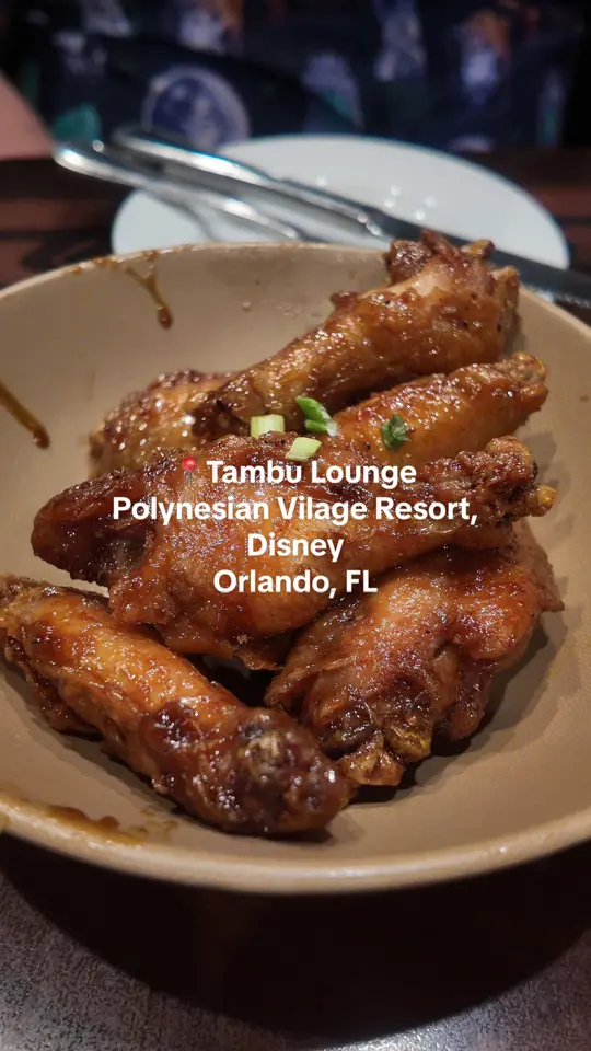 Tambu Lounge in Lake Buena Vista showing drinks, themed island sips, food, ‘ohana noodles, potstickers, honey-coriander chicken wings, video by michellemunches on TikTok