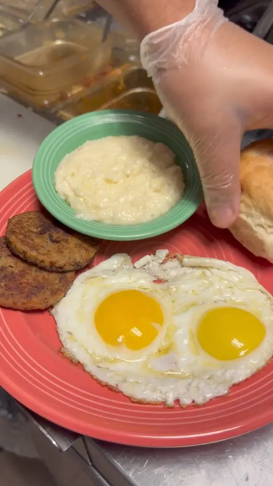 The Flying Biscuit Cafe in Peachtree City showing food, two eggs, bacon or sausage, creamy dreamy grits, fluffy flying biscuit, video by Flying Biscuit Cafe- Peachtree City on Facebook