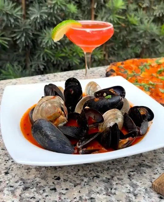 Wood & Fire in Delray Beach showing happy hour, 50% off drinks, $3 off appetizers, $3 off pizzas, video by Wood & Fire Delray on Facebook
